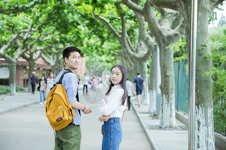 去校园路上青春男女学生走在校园路上回头背景