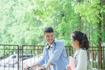 一推书青春大学生推自行车散步聊天背景