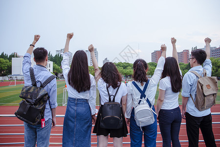 欢乐女操场上青春活力大学们举手握拳背景