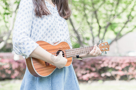 悦耳动听弹尤克里里的女孩背景