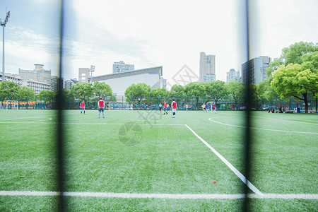 校园阳光足球场老人在踢球背景图片