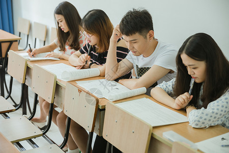 女写字校园教室同学们在写卷子背景