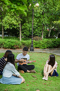 校园男女大学生男女草地休息听弹奏背景