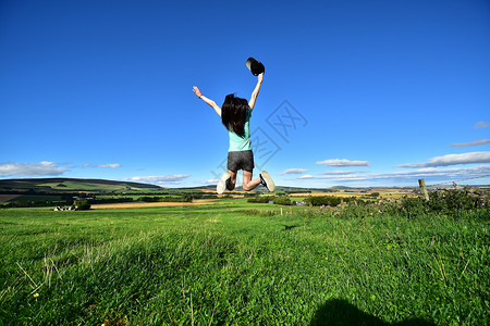 草地上跳跃的女孩背景图片