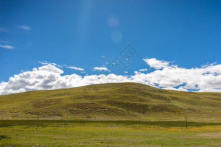 蓝天白云下的草原山峦背景图片