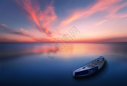 夕阳麋鹿一艘独木舟漂浮在平静的水面上背景
