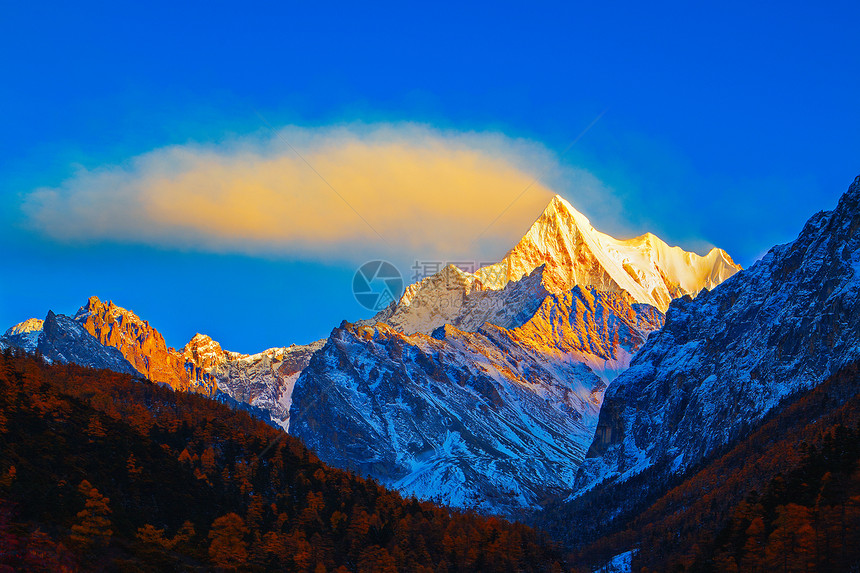 夏诺多吉雪山的日照金山和飘动的云图片