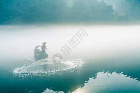 渔夫打鱼渔夫在起雾的江中撒网打鱼背景