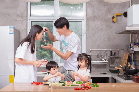 孩子在厨房年轻父母与孩子一起在厨房做饭背景