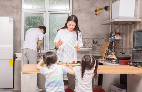 年轻父母与孩子一起在厨房做饭家庭高清图片素材