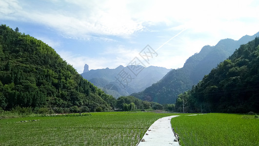 素材乡间小路蓝天白云下的远山田野和乡间小路背景