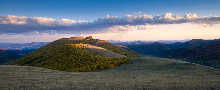 树林远山夕阳下的山峰光影全景背景