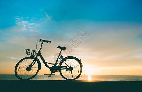日出天空海边自行车高清图片