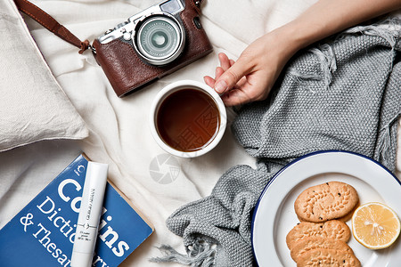 床和早餐创意生活氛围相机咖啡和饼干书本背景