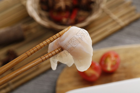 筷子夹着牛蛙鱼肉背景