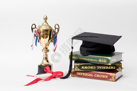 学士帽和冠军奖杯组合摄影图背景图片