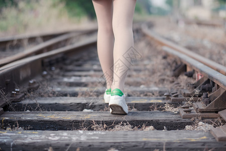 旅行的路上铁路上走路的女孩背景