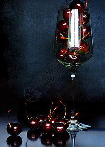 高脚杯里的红樱桃背景图片