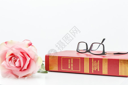 书与玫瑰桌子上的眼镜与书背景