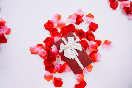 酒红色贺卡信封玫瑰花瓣和礼盒背景