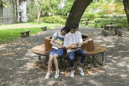 学吉他学校绿荫下男女同学在一起学音乐恋爱背景