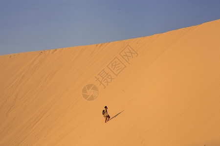 一个人孤独的在沙漠里行走背景图片