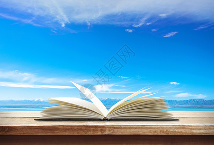 水天之间蓝色天空下展开的书本设计图片