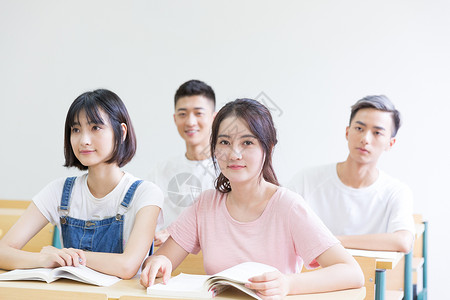 女大学生书本在教室里的高中生背景