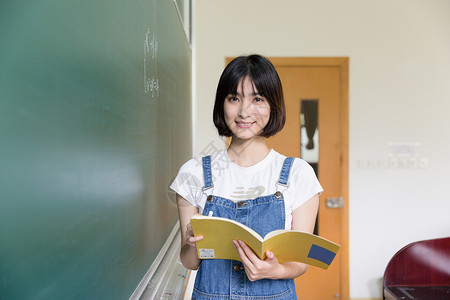 正在读书正在教室黑板写板书的女生背景