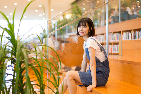 图书阶梯坐在图书馆里的女生形象照背景