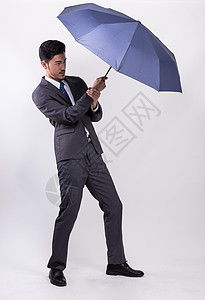 打伞商务男士撑着伞的商务人士背景