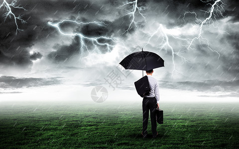 信贷危机打伞商务人站在打雷下雨的草坪上设计图片
