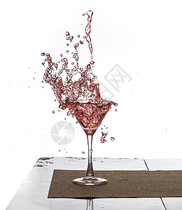 粉红色饮料溅在玻璃杯中的水珠高清图片