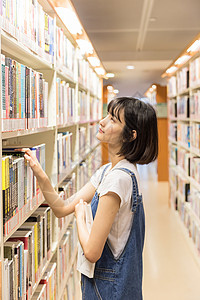 大学女生图书馆书架找书背景图片