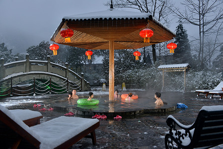 小孩雪在冰天雪地里享受热气腾腾的温泉背景