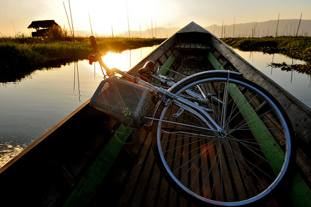 小木船载着游客及自行车航行在湖泊水道上背景图片