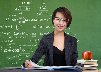 眼镜模特女老师在黑板前批改作业设计图片