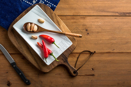 红板菜板上的辣椒和大蒜背景