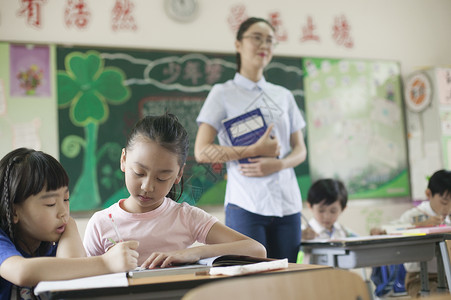 上课时老师在辅导学生认真学习图片