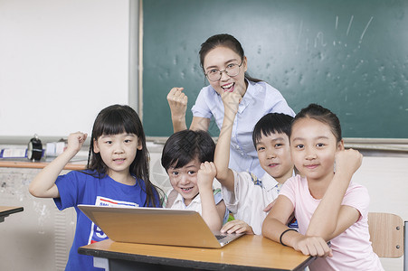 计算机教育女老师和同学们在教室里接受远程教育背景