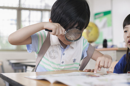 小学生同学在教室里一起研究学习背景图片