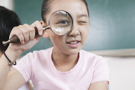 女同学在教室用放大镜研究高清图片
