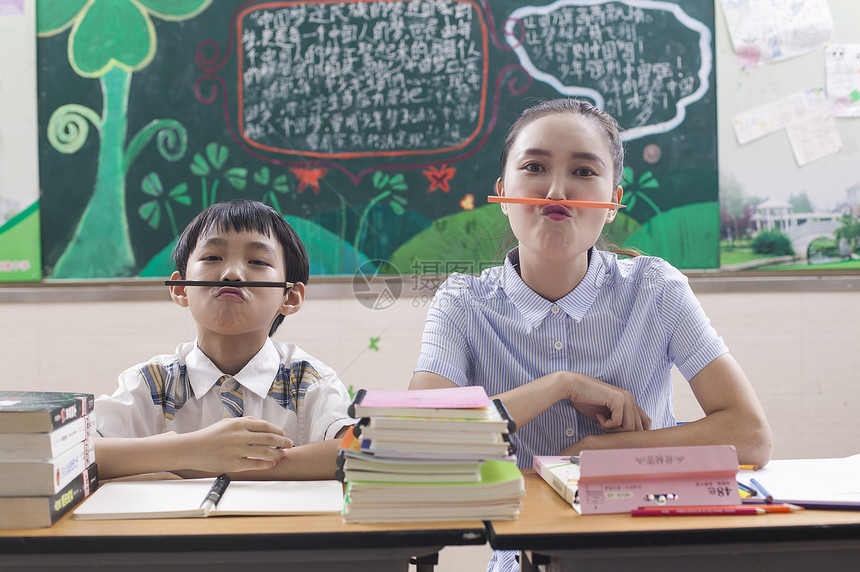 教室里女老师陪男同学学习玩耍图片