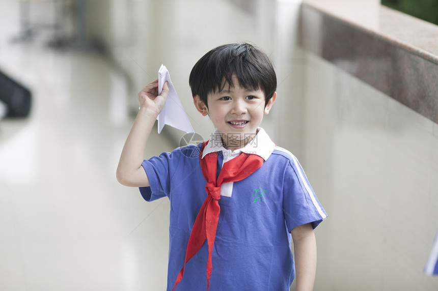 男学生在学校里折飞机玩耍图片