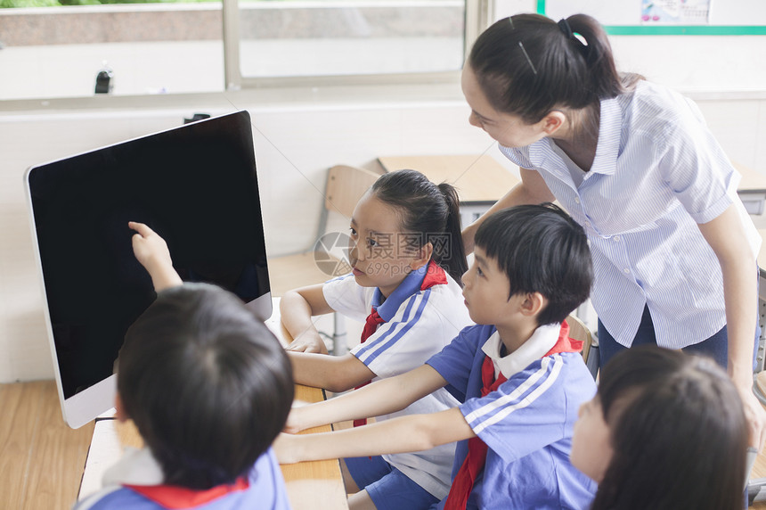 女老师和同学们在教室里用电脑上课