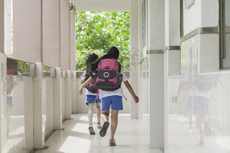 女同学背着书包放学下课背景图片