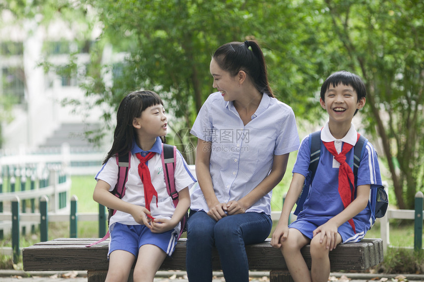 女老师和男女同学在校园里一起学习图片