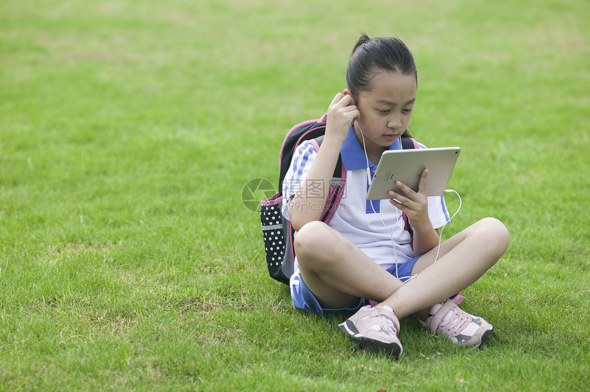 女同学在学校草坪上用ipad学习图片