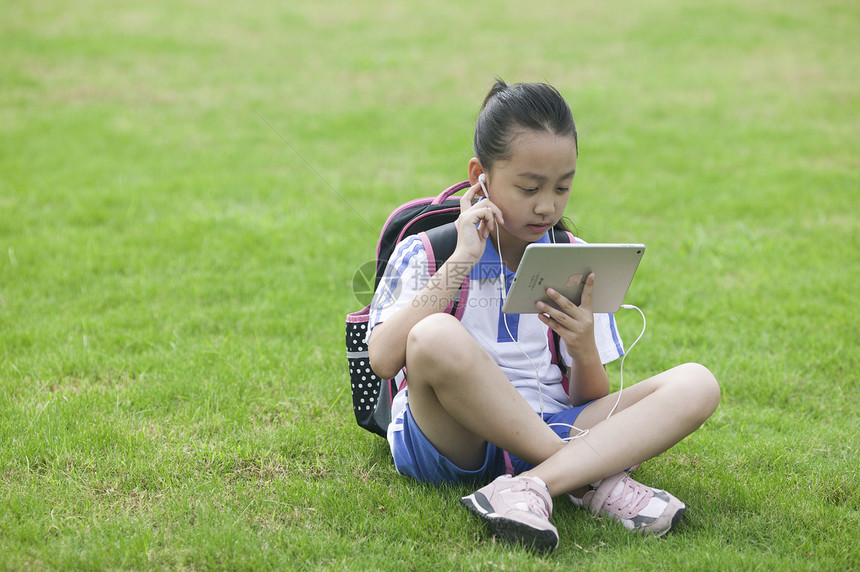 女同学在学校草坪上用ipad学习图片