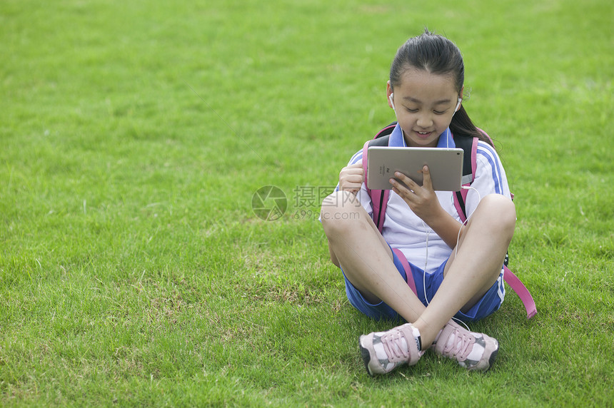 女同学在学校草坪上用ipad学习图片